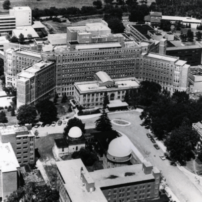 Aerial view of the Old University Hospital at the University of Michigan, featuring the hospital building, streets, trees, and surrounding buildings.