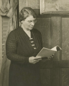 Agnes Ermina Wells standing and reading a book
