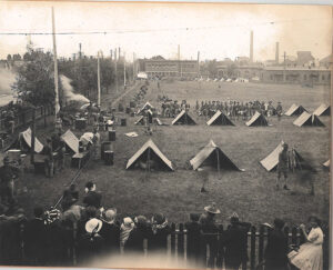 Tents and people observing a military camp, 1913
