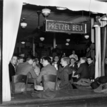 Black and white photo looking into the Pretzel Bell restaurant in 1937, several male students seated at a window table.