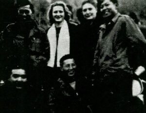 John Nakamura (Left) and Lefty (Right) standing with two French women singers and other soldiers.