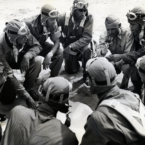 Men crouched in a circle for a Tuskegee AAF Training Command Briefing in 1943.