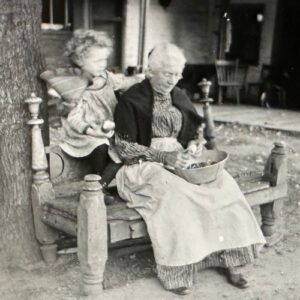 A grandmother with a child peeling apples