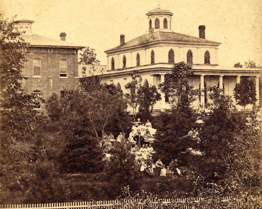 A group portrait of students sitting on a hill in front of Lucinda Hinsdale Stone's house in Kalamazoo.