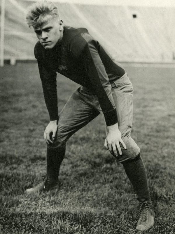 Gerald Ford in his University of Michigan football uniform on the football field.