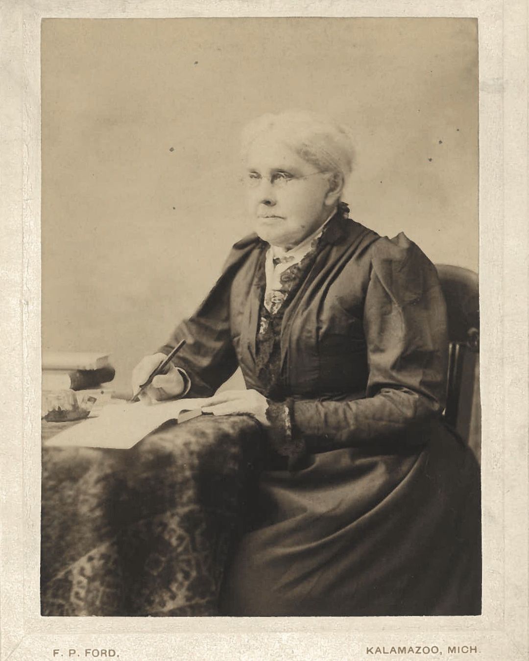 Lucinda Hinsdale Stone sitting at a desk and writing.