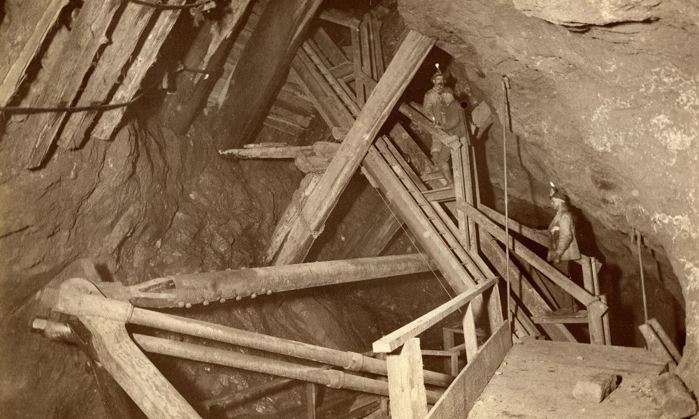 Miners in Quincy Mine in the Upper Peninsula, with a mine interior, miners, and wooden struts.