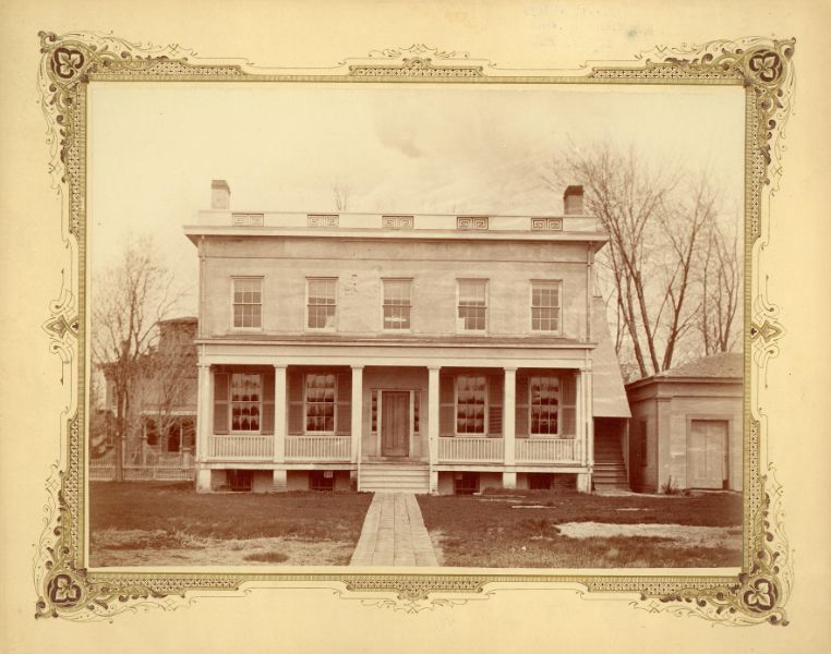 Northwest Professors' House, a building with a porch with simple columns and a long straight walkway through a grassy lawn.
