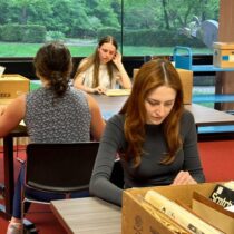 Students looking at historical materials during the History of Hate Michigan in the World program.