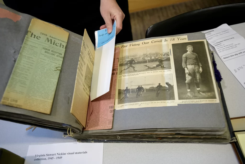 An open scrapbook with old newspaper articles glued to the pages.